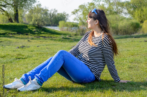 Woman Sitting Outdoors on Grass Near Lake