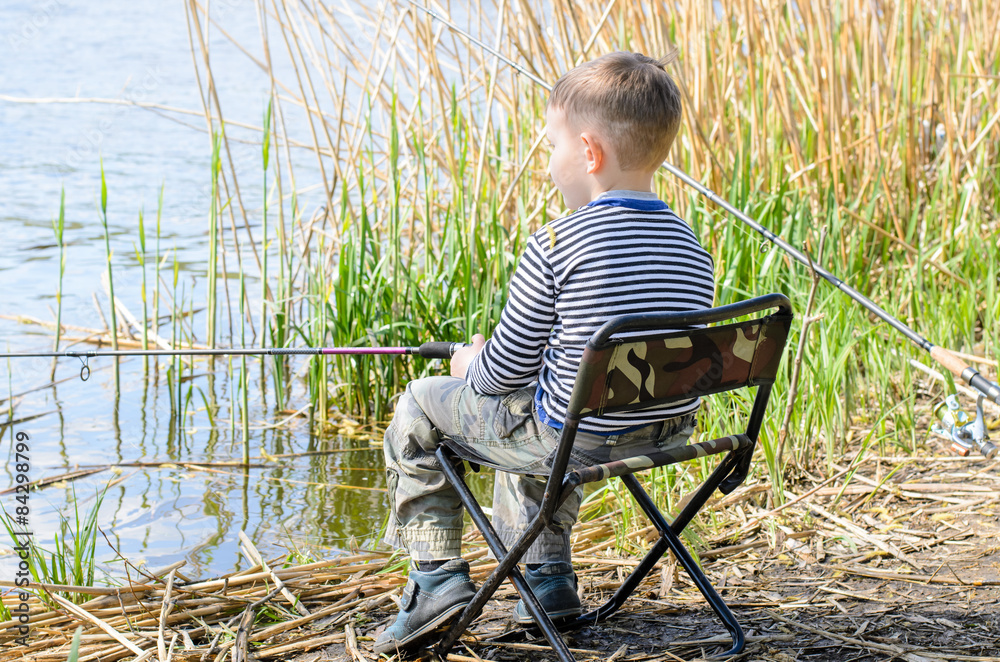 Boy Sitting in Chair and Fishing Amongst the Reeds Boy Sitting in Chair and Fishing Amongst the Reeds