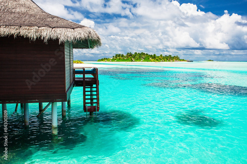 Over water bungalow with steps into amazing blue lagoon with isl