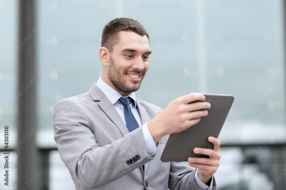 smiling businessman with tablet pc outdoors
