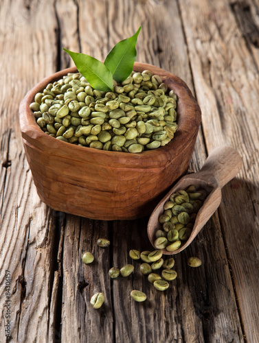 green coffee beans in wooden bowl