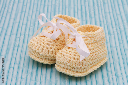 Pale Yellow Baby Booties on wood background