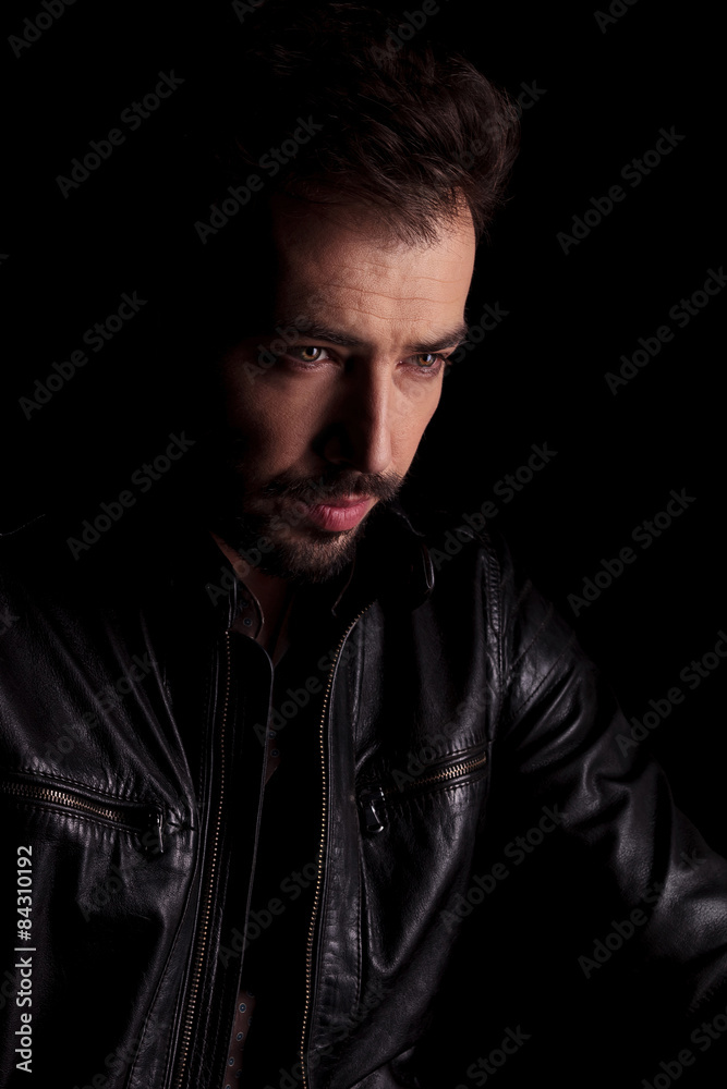 handsome young man thinking while looking down. handsome young man thinking while looking down.