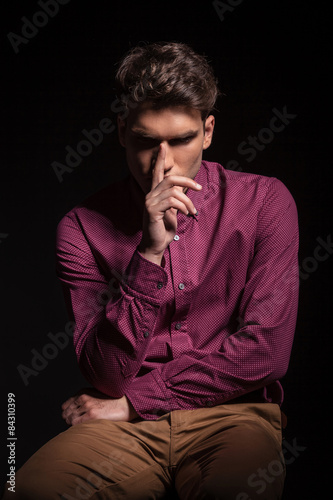 Young casual man holding one hand to his nose.