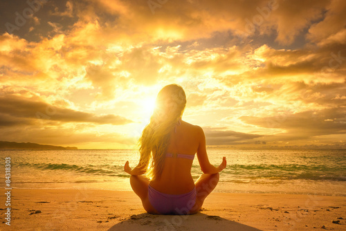 Photography Young woman relaxing in lotus position during a beautiful sunset