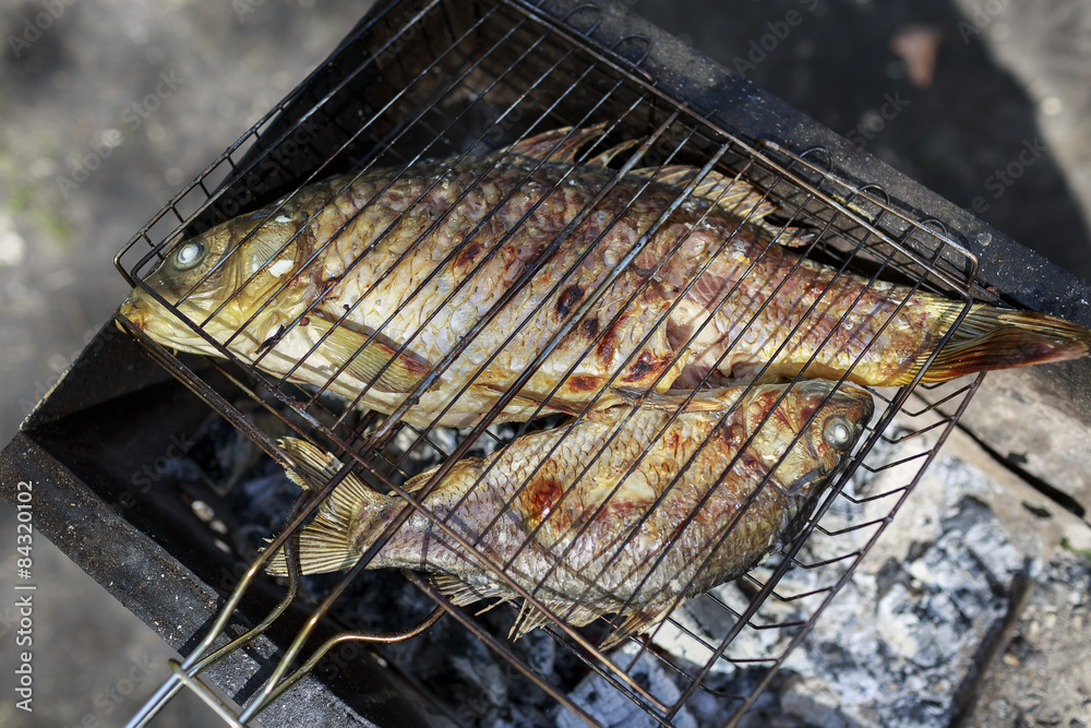 Two grilled carp on bbq fireplace