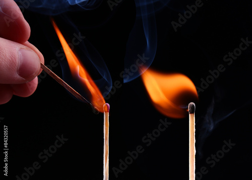 Ignition of a match, with smoke on dark background