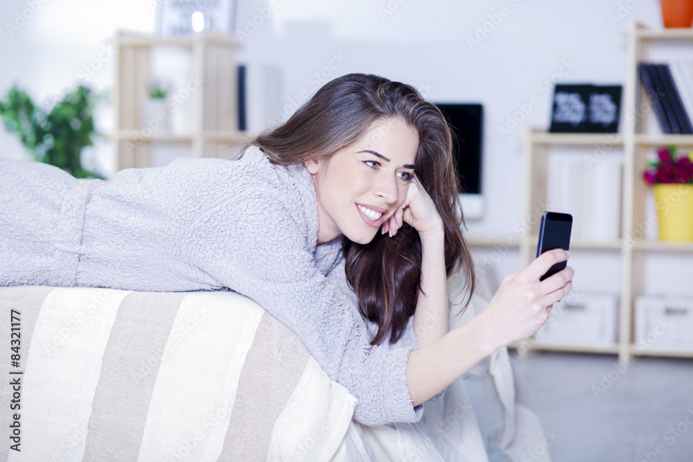 Woman in bed with coffee, tablet, computer, phone laughing Woman in bed with coffee, tablet, computer, phone laughing