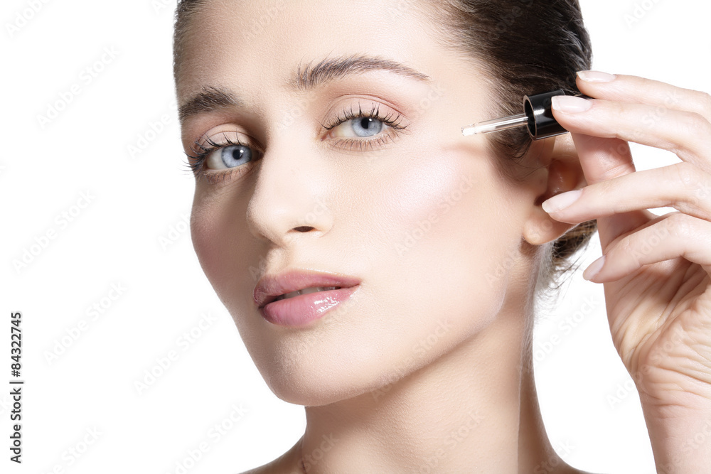 beautiful model applying a skin serum treatment