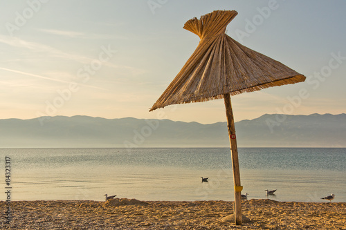 Fototapeta Naklejka Na Ścianę i Meble -  umbrella, pebble beach and seagulls
