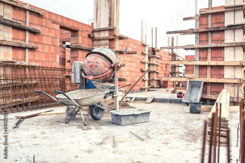 Obraz na płótnie Cement mixer machine at construction site, tools, wheelbarrow