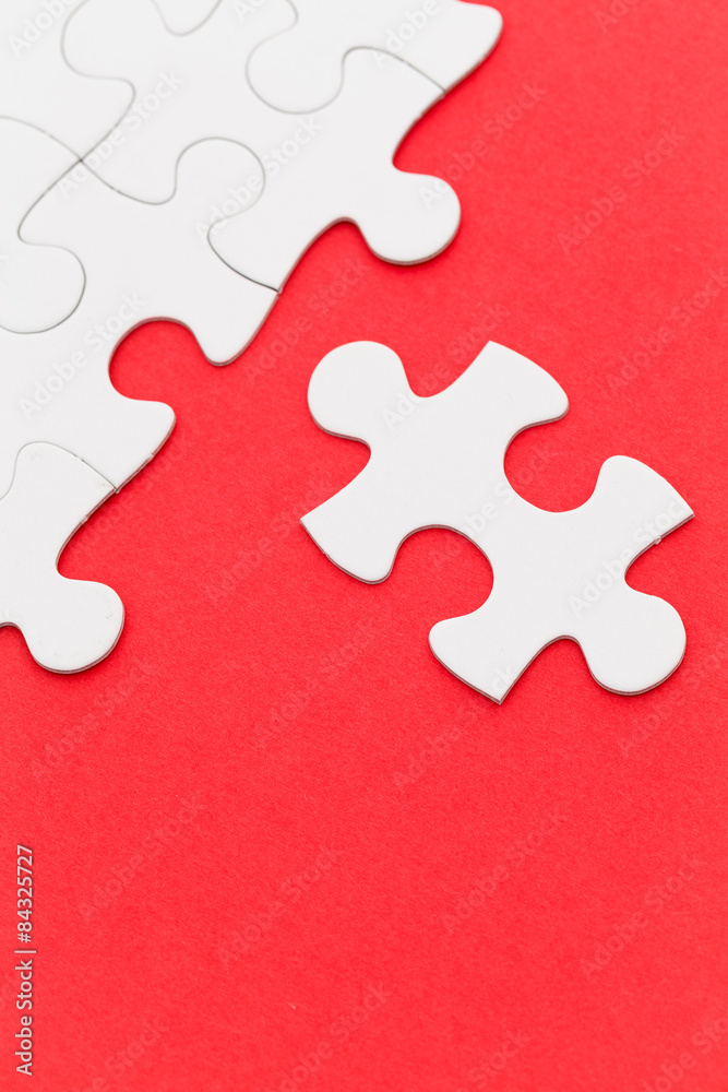 Incomplete white puzzle with red color background Incomplete white puzzle with red color background
