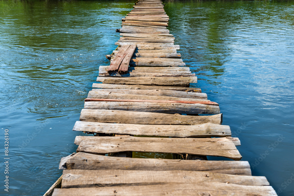 Fototapeta premium Old wooden bridge through the river