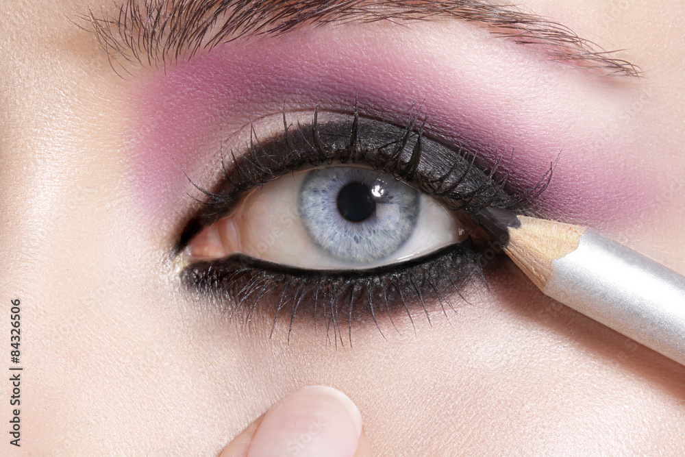 Naklejka premium Close up on eyes , making colorful eyeshadows and eyeliner