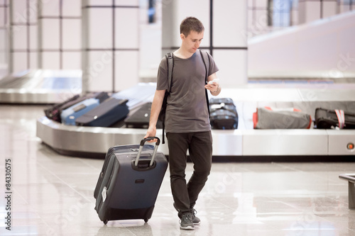 фотографія Traveller at conveyor belt texting
