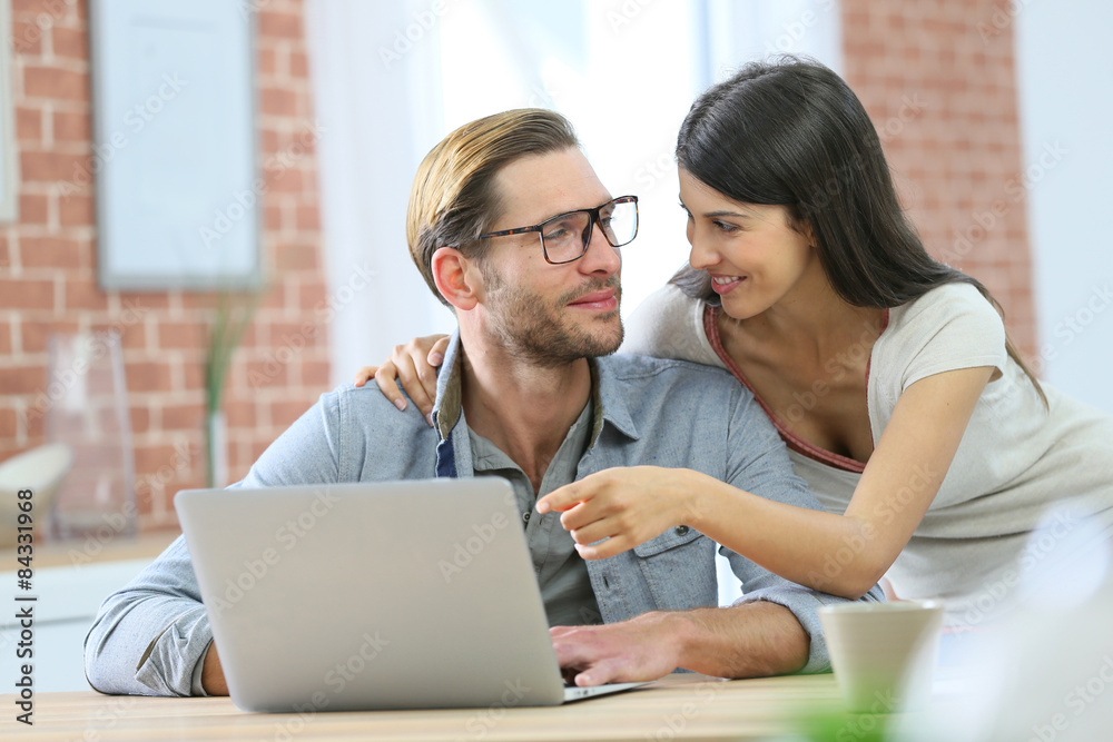 Couple at home websurfing on laptop computer Couple at home websurfing on laptop computer
