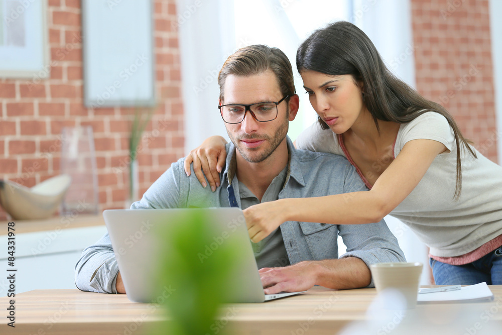 Couple at home websurfing on laptop computer Couple at home websurfing on laptop computer