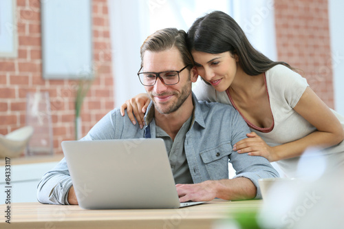 Couple at home websurfing on laptop computer