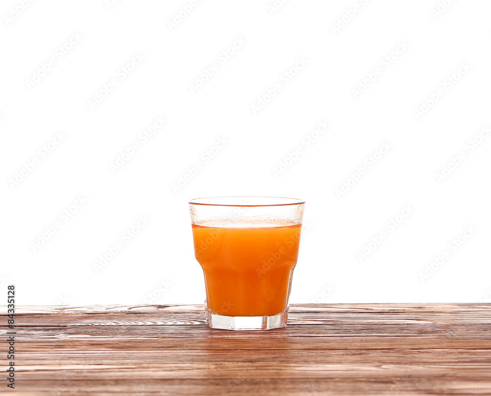 Carrot juice in glass with fresh organic carrots on white wooden table