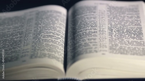 The Bible on a black background. Turning the pages of the Holy