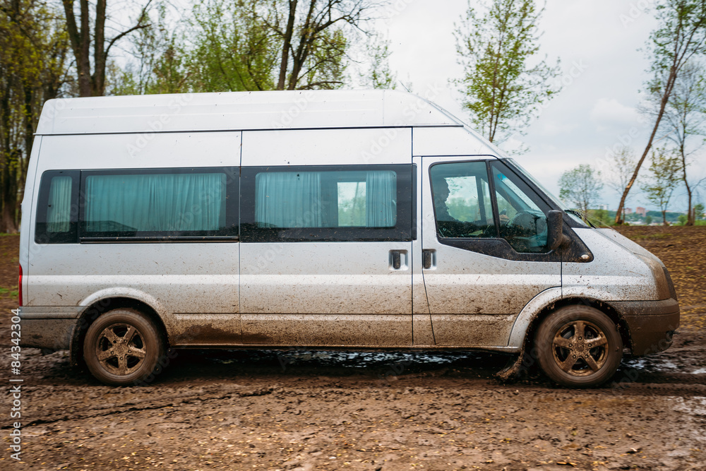 Fototapeta premium Very Dirty Car Minivan Stalled In The Mud.