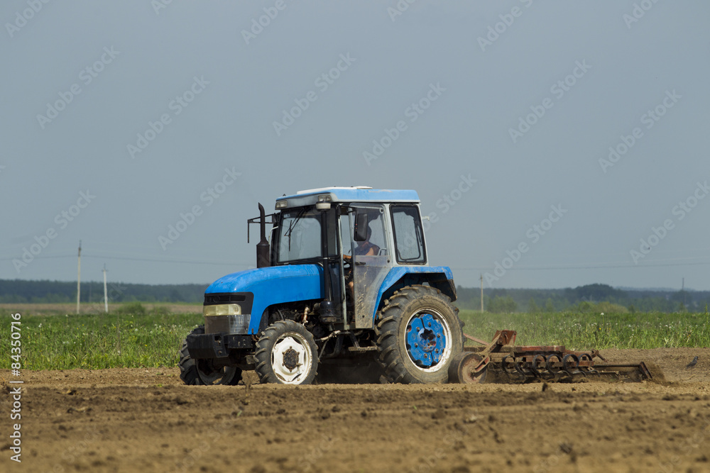 The tractor in the field on agricultural operations.