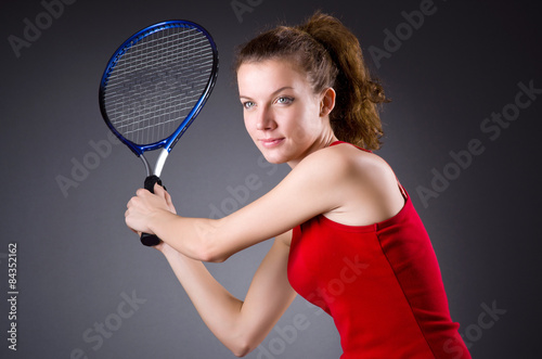 Woman tennis player against dark background