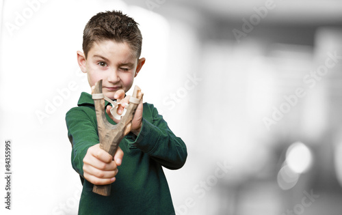 Plakat little kid using a slingshot