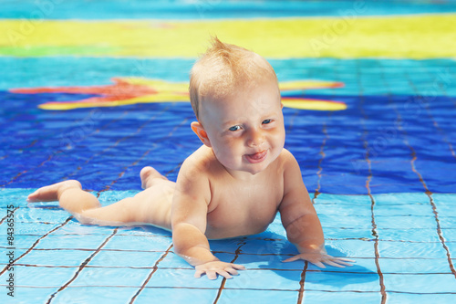 Face portrait of little child swimming with fun in pool photo