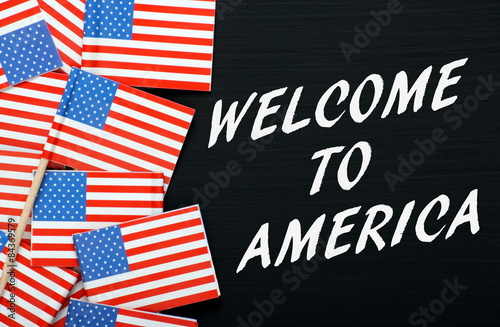 Welcome to America on a blackboard with USA flags