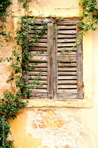 Принти на полотні Shuttered window and ramshackle wall of old Italian house.