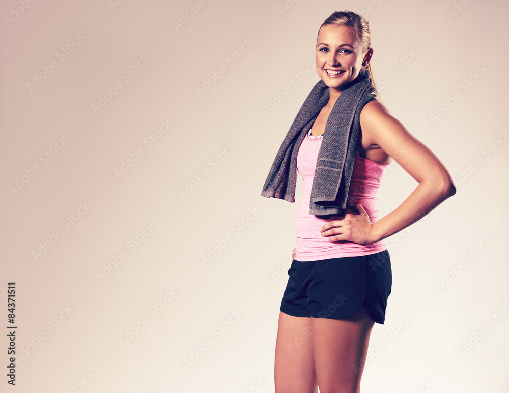 Fototapeta premium Woman posing with hand on hip wearing workout clothes.