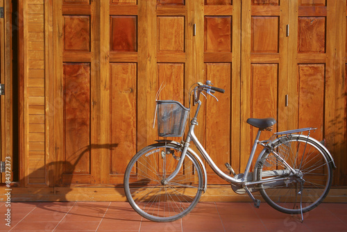 vintage bike parked next to a wooden wall