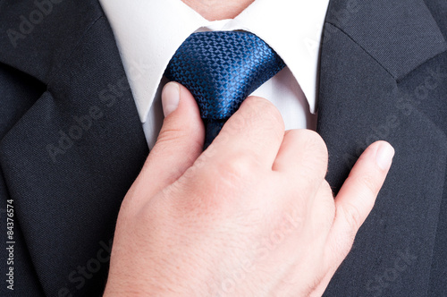 Successful manager fixing blue tie