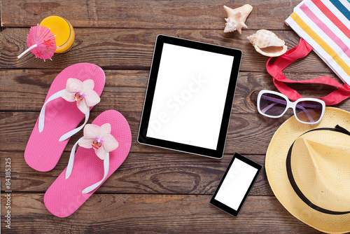 Photography Blank empty tablet computer, summer accessories on beach.