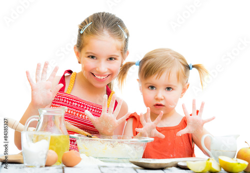 cute little sisters baking on kitchen