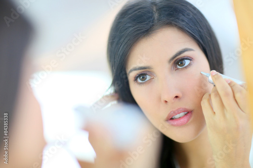 Portrait of beautiful woman using cosmetics
