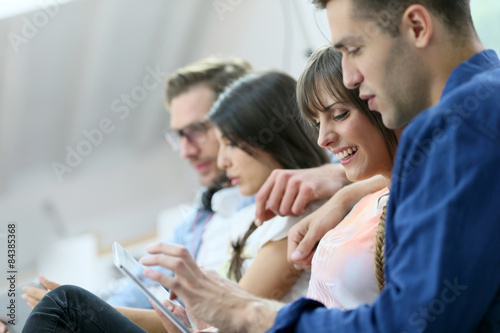 Group of friends relaxing in sofa and using tablet