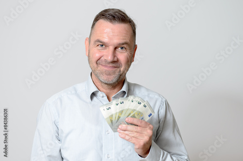 Mann hält einen Fächer von Euro-Noten