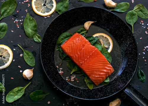 Salmon in frypan on black backgroung
