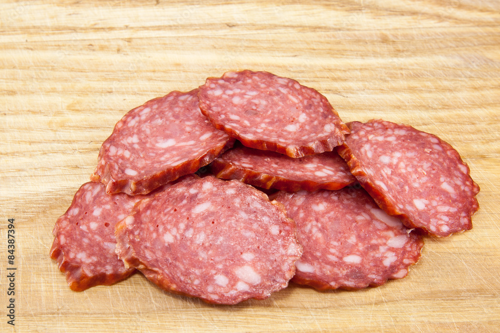 salami sausages on wooden board isolated