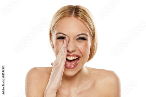 very happy young woman holding hand beside her mouth and shout