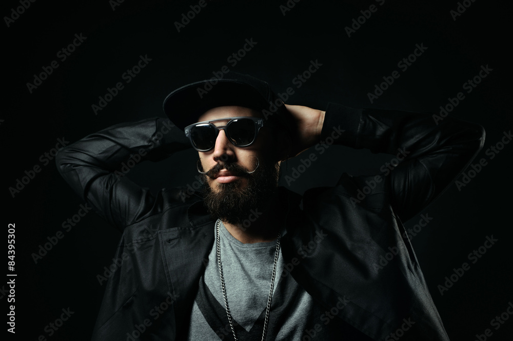 The bearded man in a sunglasses clasped his hands behind his hea The bearded man in a sunglasses clasped his hands behind his hea