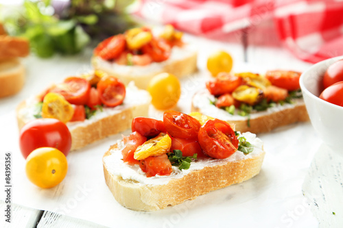 Tasty fresh bruschetta with tomatoes on white wooden background