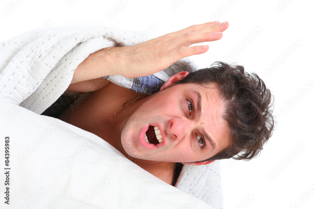 furious man in bed on white background
