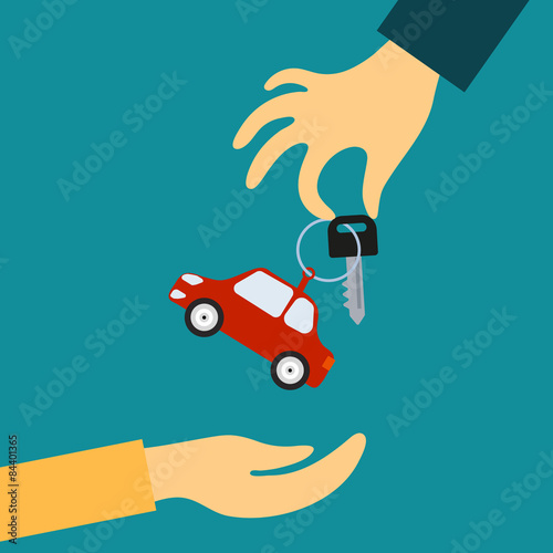 Hand of the seller holds out a key with a tag in the form of car