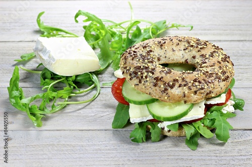 Käsebagel mit Rucola auf Holztisch photo