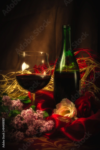 Glass and Bottle of Red Wine in Elegant Setting Under Soft Light