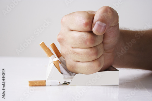 Hand crushing cigarettes photo