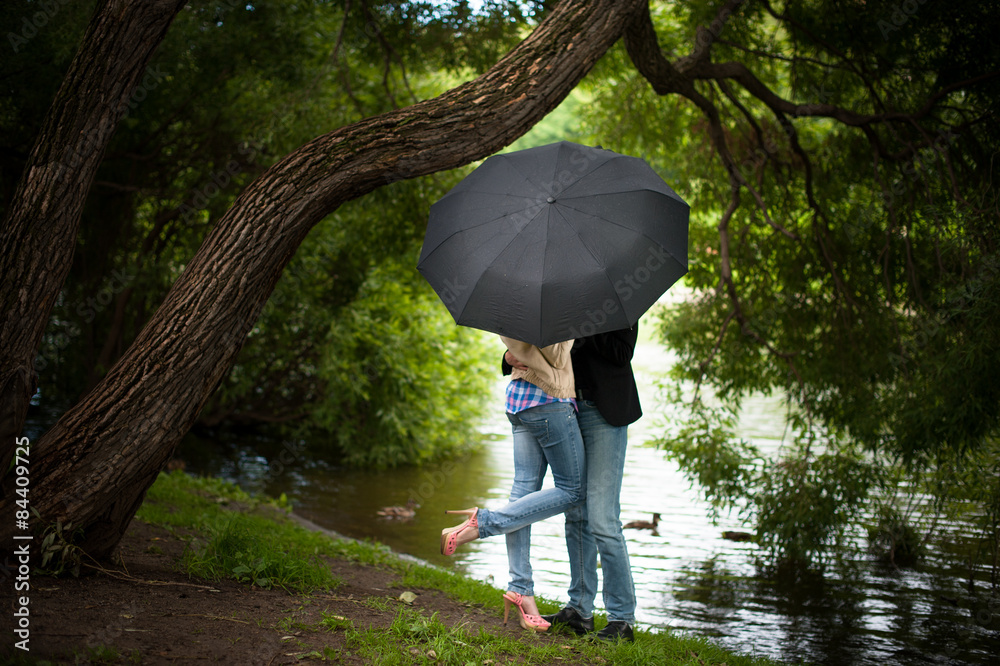 Loving couple standing under an umbrella
Loving couple standing under an umbrella